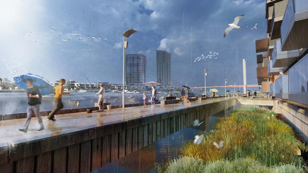An artist’s impression of what the North Wharf Road River Frontage might become. The image shows pedestrians walking under umbrellas, along the promenade that is built over the river as it merges with the harbour. This walkway passes a variety of residential buildings and native grasses to the right, with city buildings along the skyline.  